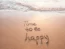 Time to be happy written on a beach
